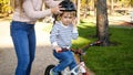 Closeup photo of young caring woman putting on protective helmet on her son riding a bicycle Royalty Free Stock Photo