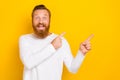 Closeup photo of young handsome funny redhair bearded guy finger pointing empty space crazy sale isolated on yellow