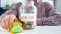 Closeup photo of young man buying new car. Jar full of money and miniature toy car on white table Royalty Free Stock Photo