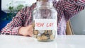 Closeup image of young man with glass jar full of money for buying new car Royalty Free Stock Photo