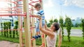 Closeup image of young mother helping her little son climbing on high metal stairs at sports children playground Royalty Free Stock Photo