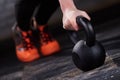 Closeup photo of young woman in the black leggings and orange sneackers while push-ups with kettlebell. Royalty Free Stock Photo
