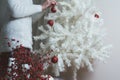 Closeup photo of young woman decorating white Christmas Tree at