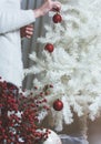 Closeup photo of young woman decorating white Christmas Tree at Royalty Free Stock Photo