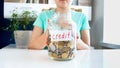 Closeup image of young woman with glass jar full of money labeled Credit Royalty Free Stock Photo