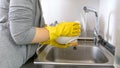 Closeup photo of young woman in rubber gloves washing dishes Royalty Free Stock Photo