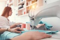 Closeup photo of young woman`s hands seamstress sitting and sews on sewing machine in creative designer studio Royalty Free Stock Photo