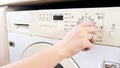 Closeup image of young woman setting water temperature on washing machine Royalty Free Stock Photo