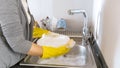 Closeup image of young woman washing dishes with detergent Royalty Free Stock Photo