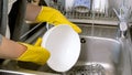 Closeup photo of young woman washing dishes in kitchen sink Royalty Free Stock Photo