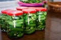 Closeup of pickles in jars arranged on a tabletop