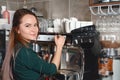 Closeup picture of barista woman making coffee by coffee machine