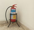 A closeup picture of a fire extinguisher placed in the corner in a Mall