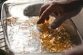 Closeup picture of ingots of yellow melt gold washing in water with hands