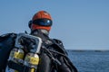 A closeup picture of a scuba diver waiting for the dive boat to get into position so he can enter the water. Ocean and