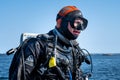 A closeup picture of a scuba diver waiting for the dive boat to get into position so he can enter the water. Ocean and