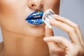 Closeup picture of woman with colorful lipstick holding ice in hand near lips Royalty Free Stock Photo