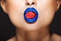 Closeup picture of woman`s colorful lips holding sweeties. Royalty Free Stock Photo