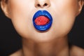 Closeup picture of woman`s colorful lips holding sweeties.