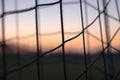 A closeup picture of a soccer net with a sunset sunrise in the background. detail ,sport, future, dreams, game football, goal, foo