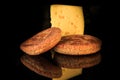 closeup piece of hard yellow cheese with two rye flapjacks