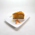 Closeup of a piece of pumpkin pie on a plate isolated on a white background