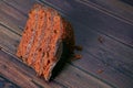 Closeup piece of tasty chocolate layer cake on dark wooden background with big copy space for recipe or text Royalty Free Stock Photo