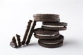 Closeup of pieces of broken sandwich cookie and stack of dark double cookies with filling