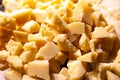 Closeup pieces of crushed broken italian hard cheese parmesan. Concept excursion cheese factory