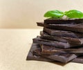 Closeup pieces of dark, inferior chocolate and green basil leaves