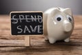 Closeup Of Piggybank By Spend Save Sign On Wood Royalty Free Stock Photo