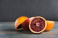 Closeup of pile of blood orange on the grey surface against black background