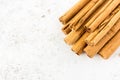 Closeup of a Pile of Cinnamon Sticks over White Speckled Background with Copy Space