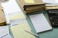 Closeup of pile document folders, bills, notebook,pen, calculator on the desk.Working process