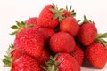 a closeup of a pile of fresh strawberries lying in a white studio