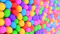 Closeup pile of gumballs with colorful rolling and falling balls form a wall. Colorful candy spheres in the pool for children fun