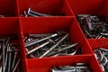 Closeup of a pile of screws in a red box.