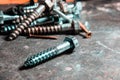 Closeup of a pile of screws on the table with a blurry background