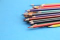 Closeup of a pile of sharp colorful pencils on a blue surface