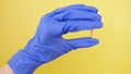 Closeup on pill capsule held in gloved hand. medical worker, doctor in lab. isolated on yellow background