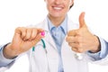 Closeup on pill in hand of smiling doctor woman Royalty Free Stock Photo