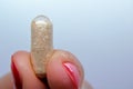 Closeup of a pill between two fingers. Medicine pill. Royalty Free Stock Photo