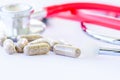 Closeup pills, capsule and stethoscope on white background.