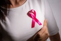 Closeup of pink badge ribbon on woman chest to support breast cancer cause. Healthcare, medicine and breast cancer awareness Royalty Free Stock Photo