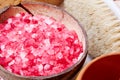 Closeup pink bath salt grain in the coconut shell Royalty Free Stock Photo