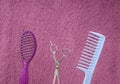 Closeup of pink brush,blue comb,scissors against hairy background.Empty space Royalty Free Stock Photo