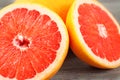 Closeup of pink grapefruit cut in half, on gray wood desk. Royalty Free Stock Photo
