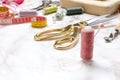 Spool of pink thread,golden scissors,measuring tape,pins and other tools for sewing on the table Royalty Free Stock Photo