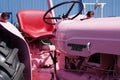 Closeup of a pink tractor parked outdoors