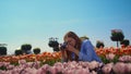 Closeup pink tulip bud and pretty girl taking photo in blooming flower park.